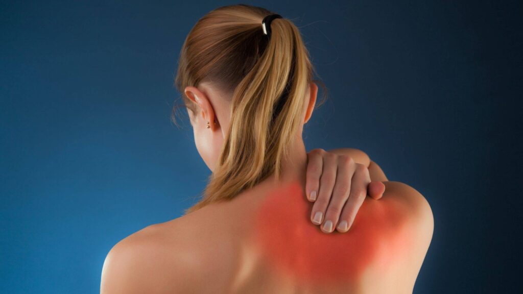 A woman holding her red back because of the muscle pain